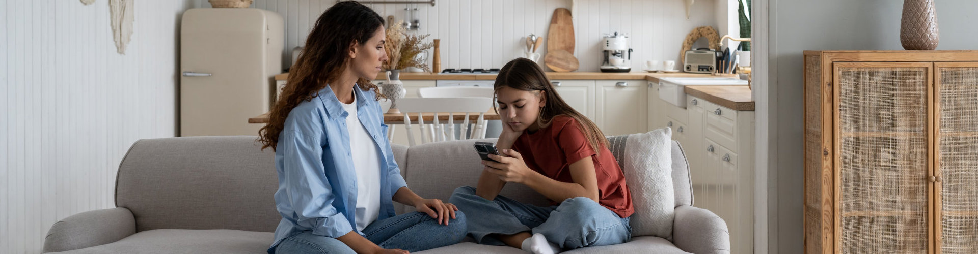 Sad teen girl holding mobile phone